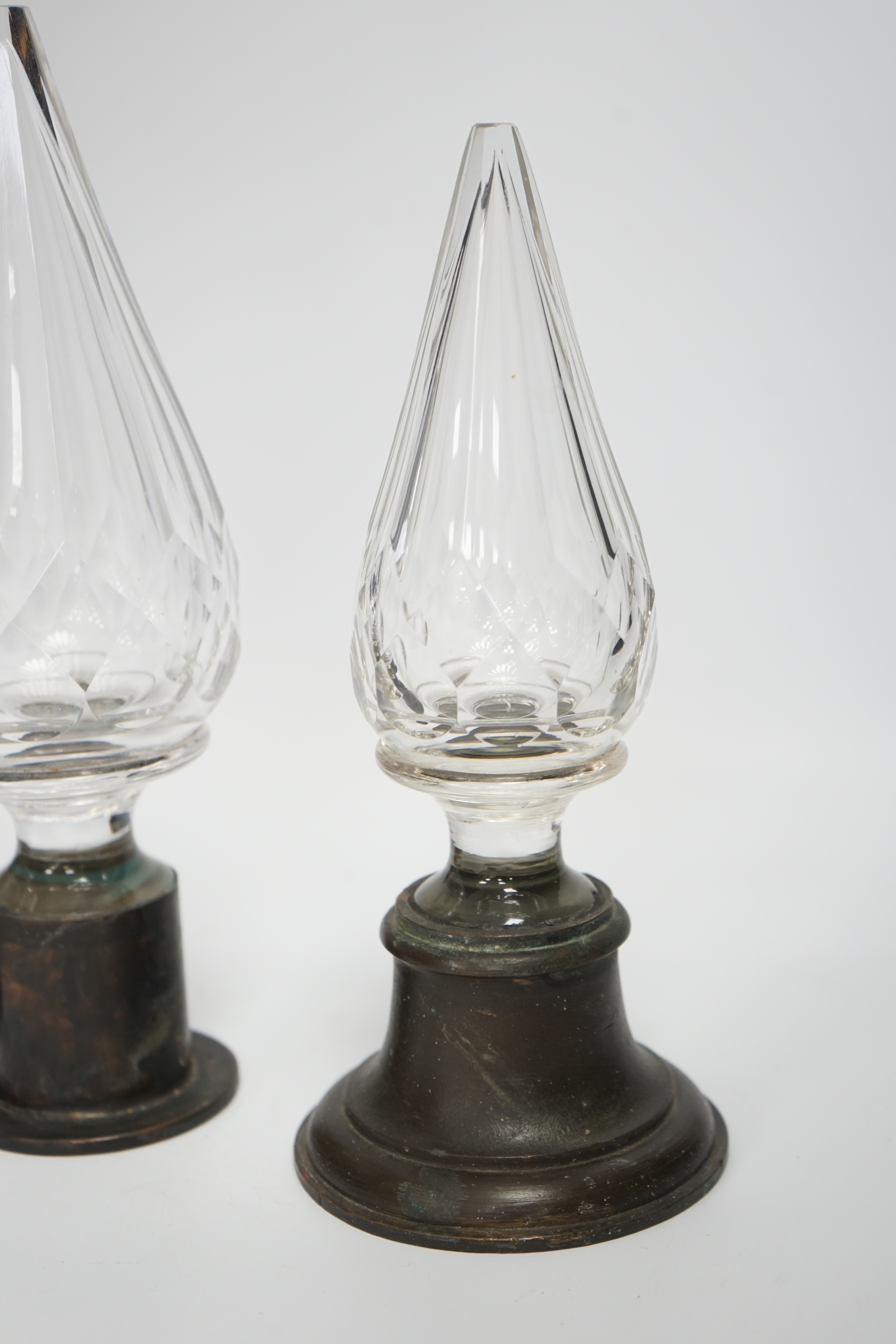 Three Large cut glass stoppers mounted on brass bases, highest 32.5cm